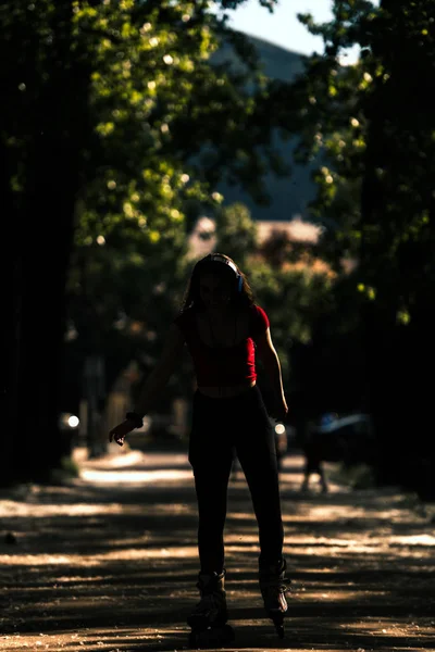 ローラーを着た若い女性は屋外でスケートをする — ストック写真