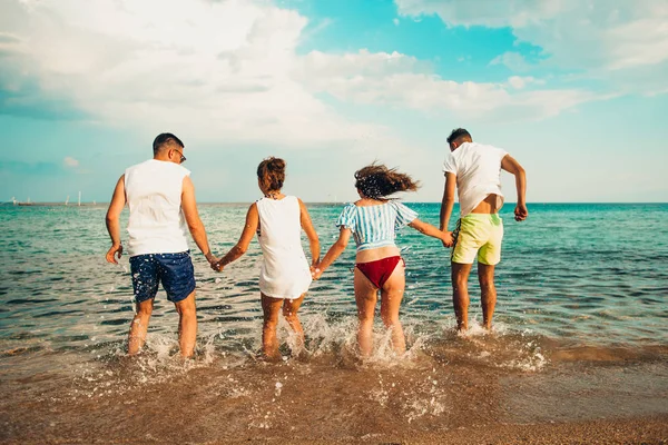 Grupo de jóvenes amigos disfrutando de una fiesta en la playa de vacaciones — Foto de Stock