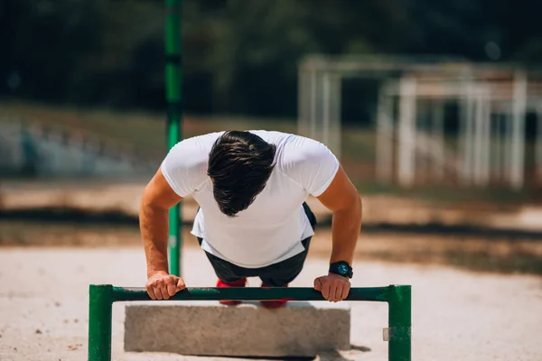 Flexiones ejercicio hombre entrenamiento pushup fuerza entrenamiento en metal —  Fotos de Stock