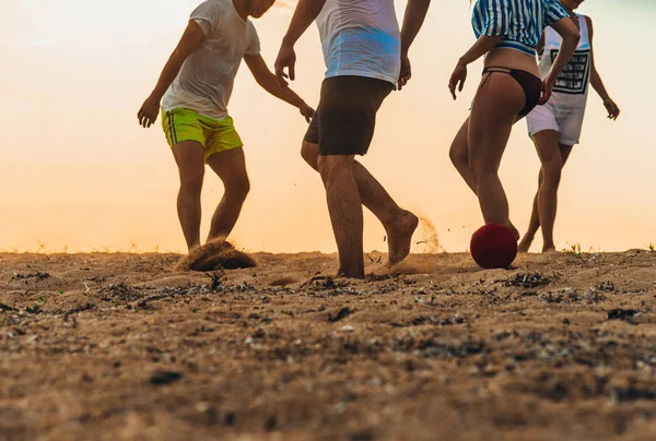Amigos multiculturais jogando futebol juntos na praia de areia — Fotografia de Stock