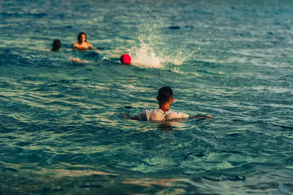 Junge Freunde spielen Wasserball im Meer — Stockfoto