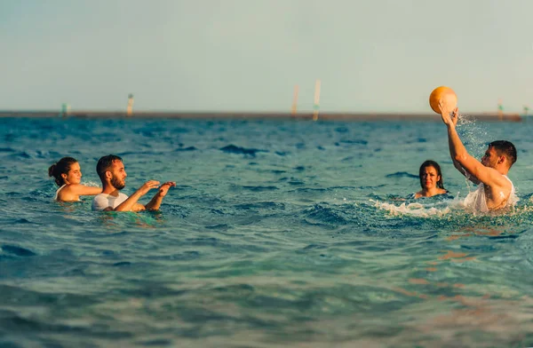 Vier vrienden trainen samen in het water met bal — Stockfoto