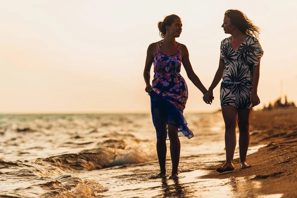 Jóvenes amigas hablando y riendo en una playa — Foto de Stock