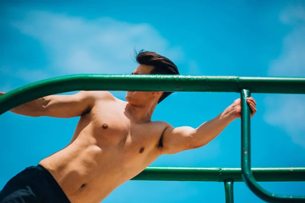 Jonge man doet abdominale oefeningen workout — Stockfoto