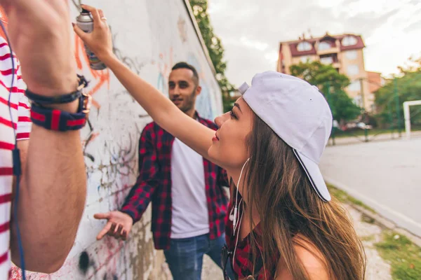 Trois amis écrivant des graffitis sur le mur — Photo