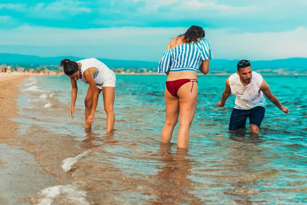 Amigos salpicando en el agua de mar y divertirse — Foto de Stock