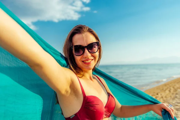 Pretty young girl dressed up in red swimwear on the beach near w — Stock Photo, Image