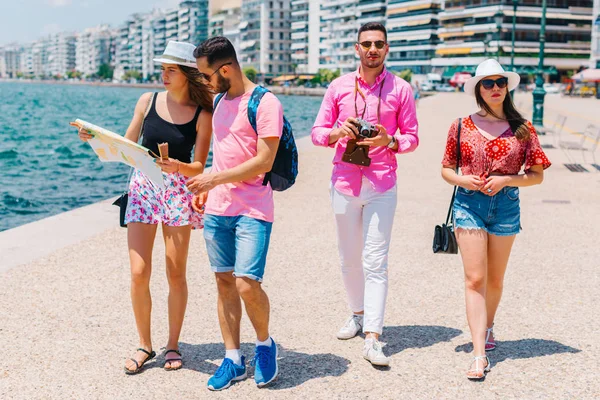 Ein Paar liest eine Landkarte, während das andere Fotos macht. — Stockfoto