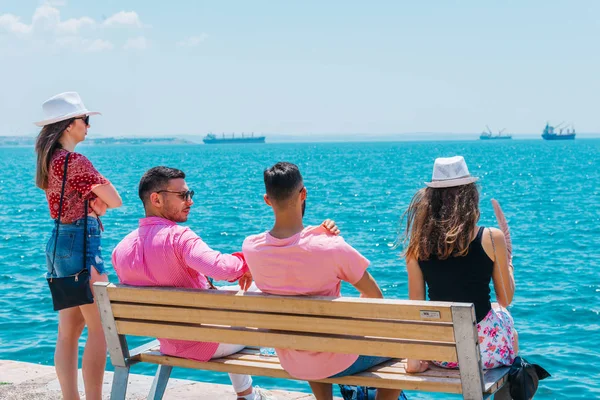 Dois casais de turistas sentados em um banco e desfrutando da respiração — Fotografia de Stock