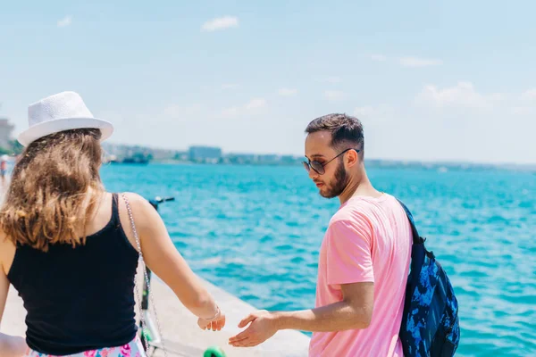 Kız hol iken bir Boardwalk üzerinde deniz tarafından yürüyüş sevimli çift — Stok fotoğraf