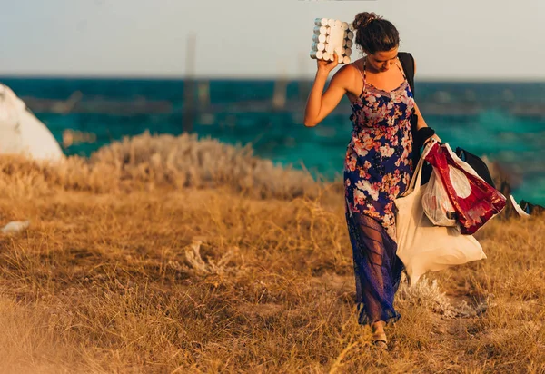 Молода дівчина в літній сукні збирається на пляжі — стокове фото