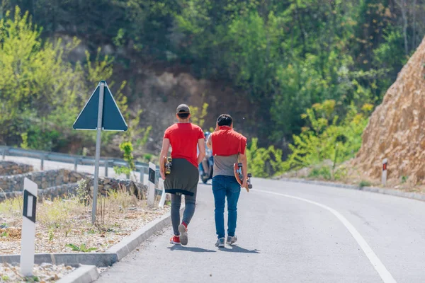 Twee mannelijke longboarders dragen hun longboards in hun handen w — Stockfoto