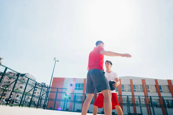 Dos amigos caucásicos con equitación deportiva roja jugando basket —  Fotos de Stock