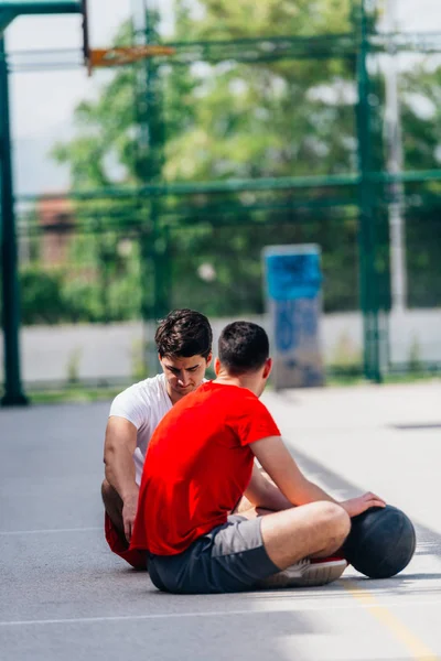 Två starka kaukasiska idrottare vilar på marken vid Baske — Stockfoto