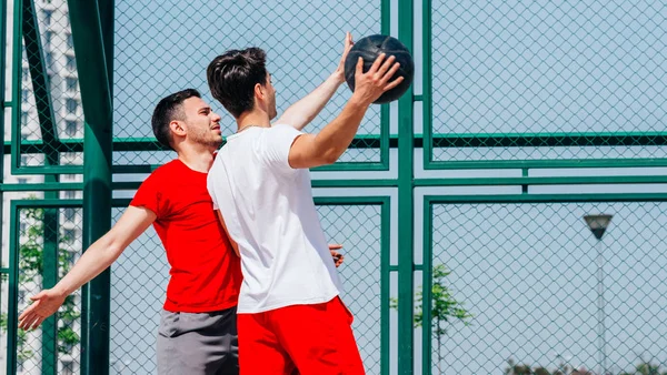 Partido de baloncesto. Jugar con una pelota negra vestida de rojo, gr —  Fotos de Stock