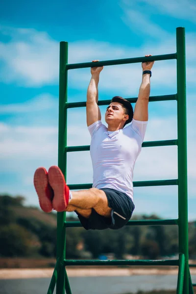 Hombre atlético joven está haciendo ejercicio abdominales —  Fotos de Stock