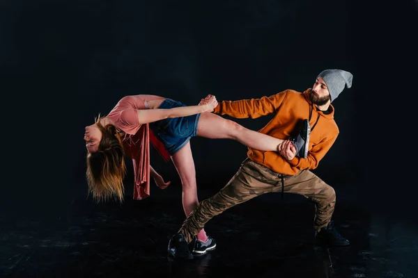 Pareja bailando danza moderna y mostrando su pierna estiramiento mo —  Fotos de Stock