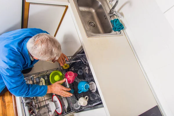 Ανώτερος στρατιωτικός που φτιάχνει το πλυντήριο πιάτων στην κουζίνα. — Φωτογραφία Αρχείου