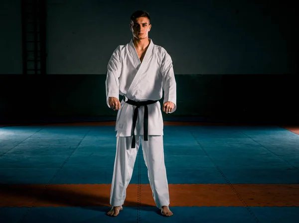 Karate harcművészetek harcos a fehér kimonó az edzőteremben — Stock Fotó