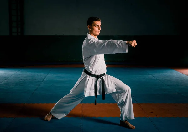 Joven luchador cinturón negro entrenamiento karate en gimnasio — Foto de Stock