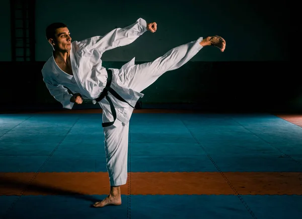 El hombre en un kimono practicando movimientos de karate — Foto de Stock