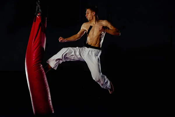 Man öva boxning på stora röda påsen i gymmet — Stockfoto