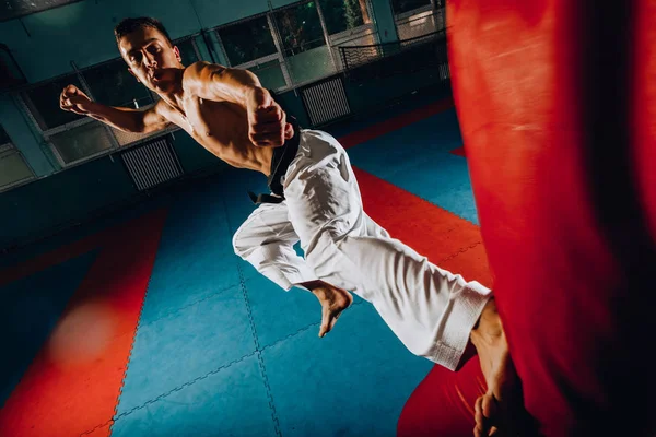 Boxeador lanza golpes en el gimnasio mientras entrena — Foto de Stock