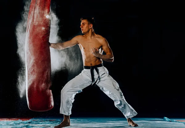 男子拳击手训练是在健身房用拳头袋练习 — 图库照片