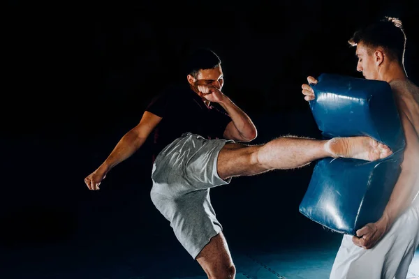 Guapo boxeador está practicando golpes con un compañero en la pelea —  Fotos de Stock