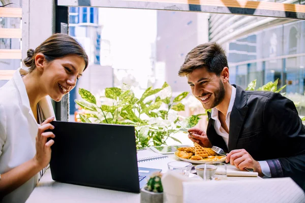 Zwei moderne Geschäftsleute, die am Tisch sitzen, während sie Laptop und D benutzen — Stockfoto