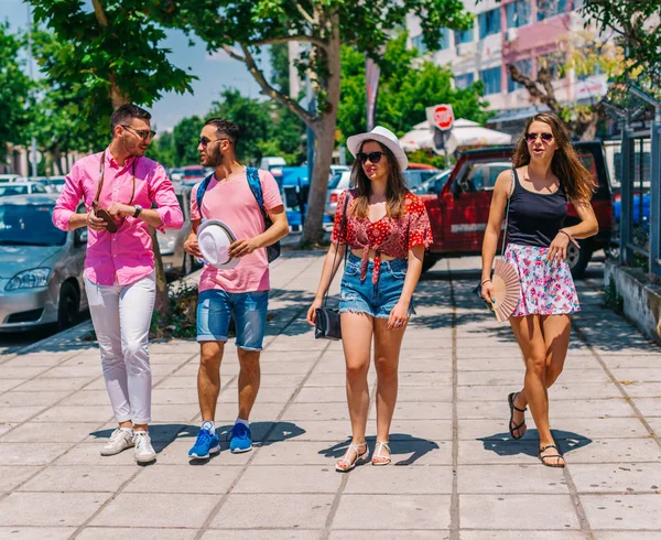 Quattro turisti (esploratori) fare una passeggiata in una città mediterranea — Foto Stock