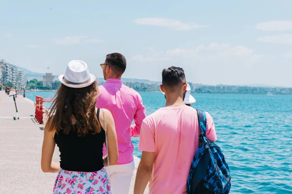 Touristen, die eine Stadt besichtigen, während sie auf einer Strandpromenade auf einem Su — Stockfoto
