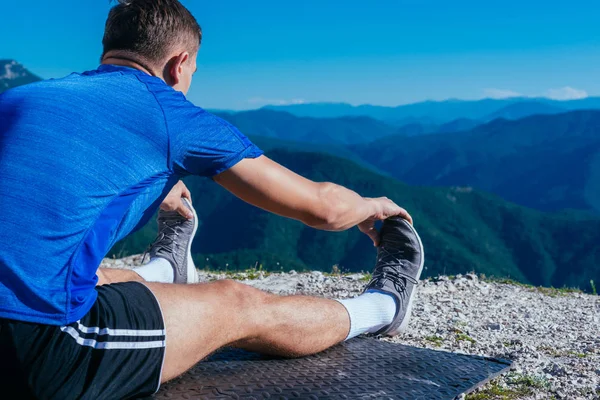 Fitness trainer die zijn dagelijkse stretching oefeningen vroeg uitvoert — Stockfoto