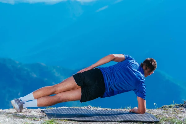 Schöner blonder Athlet macht Seitenplanke, während er seinen Bauch trainiert — Stockfoto