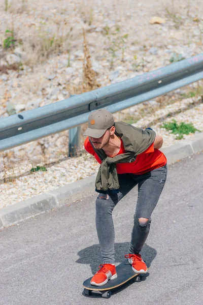 Tall fit male riding a longboard on an open road while performin — Stock Photo, Image