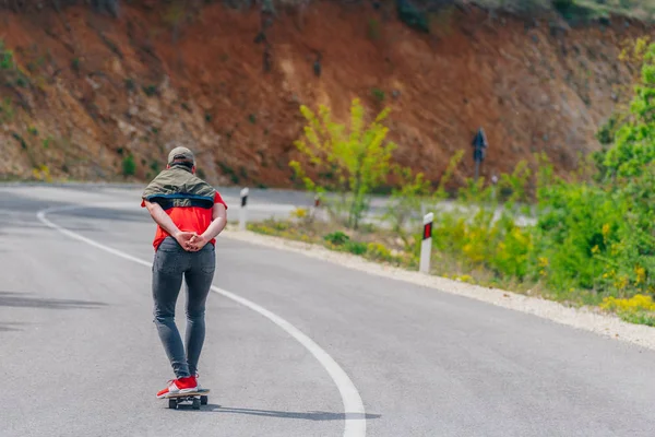 Alto atleta montando su longboard rápido y constante cuesta abajo mientras —  Fotos de Stock