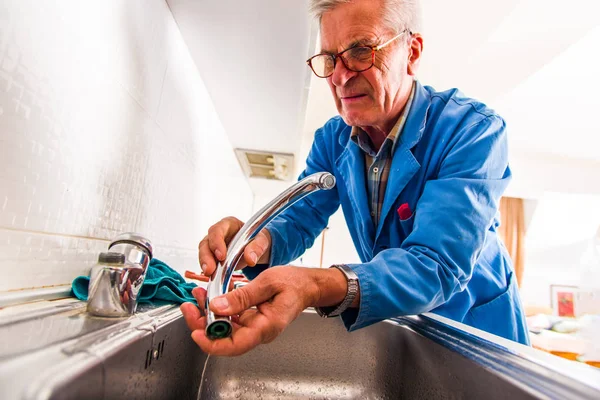 Mature Handyman Fixing Broken Kitchen Faucet — 스톡 사진
