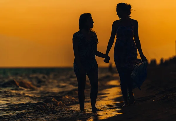 Twee mooie, aantrekkelijke jonge vrouwen die over het strand lopen — Stockfoto