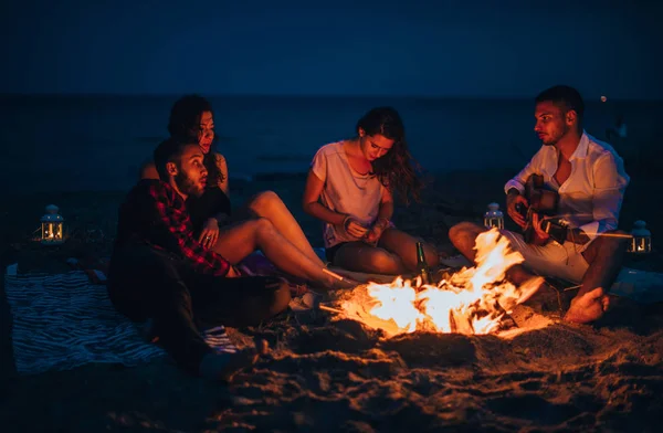 Hombre tocando una música en una guitarra a sus amigos —  Fotos de Stock