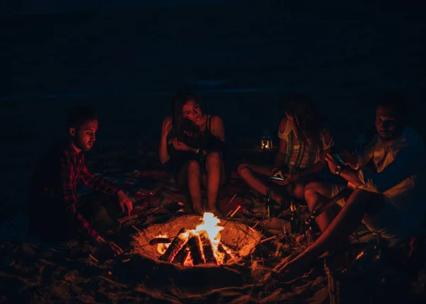 Gruppo di amici gioiosi sulla spiaggia che suonano la chitarra in estate — Foto Stock