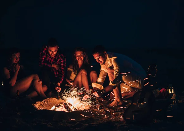 Amis heureux avoir du plaisir autour de feu de joie — Photo