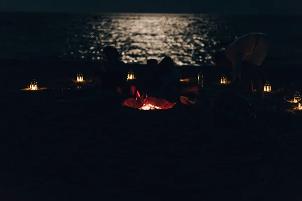 Des amis qui s'amusent à la plage la nuit — Photo