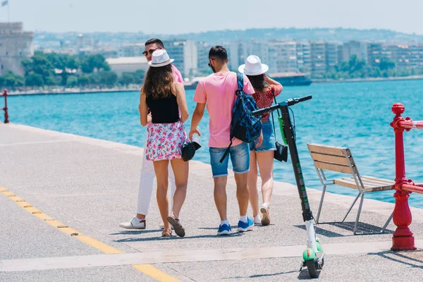 Touristen, die eine Stadt besichtigen, während sie auf einer Strandpromenade auf einem Su — Stockfoto