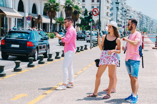 Poucos turistas chamando um táxi na hora de congestionamento ocupado enquanto espera — Fotografia de Stock