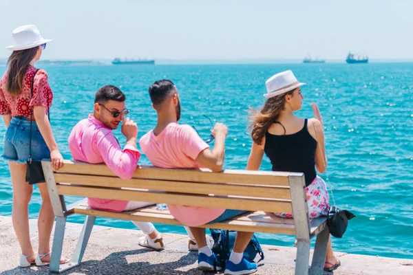 Due coppie di turisti seduti su una panchina e godendo il respiro — Foto Stock