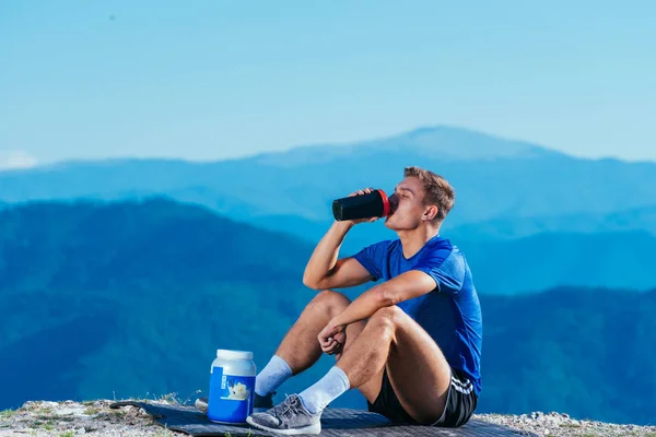 运动员 运动员 在欣赏湖水美景的同时 也在山顶喝水 — 图库照片