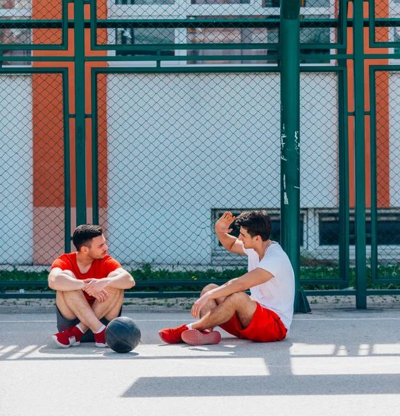 Два Сильных Кавказских Спортсмена Отдыхают Земле Баскетбольной Площадке Время Беседы — стоковое фото