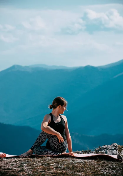 魅力的な女性の肖像画は川を見下ろす岩の上のヨガを練習します — ストック写真