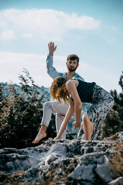 Ballerino in stile moderno in posa sulla montagna contro il cielo blu — Foto Stock