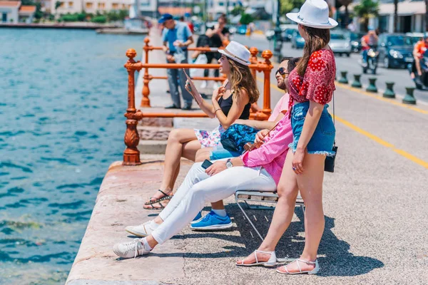 Dois casais de turistas sentados em um banco e desfrutando da respiração — Fotografia de Stock